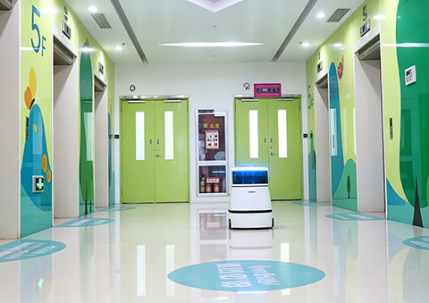 InterCon autonomous commercial cleaning robot scrubbing hospital hallway floors with anti-bacteria design.